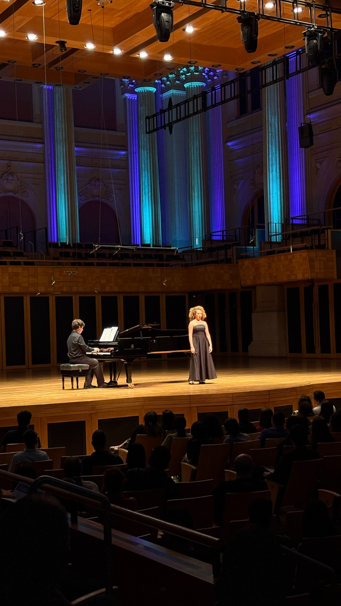 Apresentação musical em uma sala de concertos com público reunido